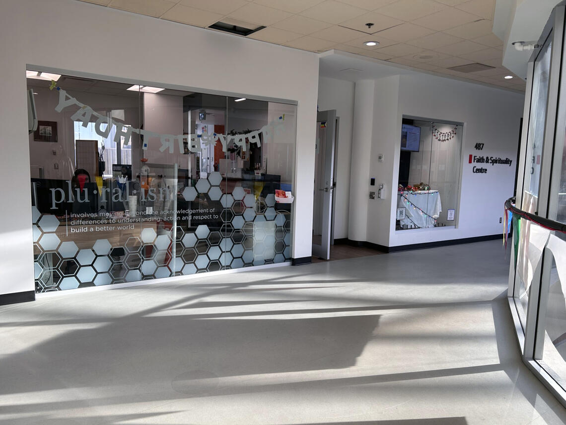 A foyer of glass windows and doors leading into the Faith and Spirituality Centre