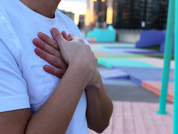 Man in white t-shirt with arms folded across chest