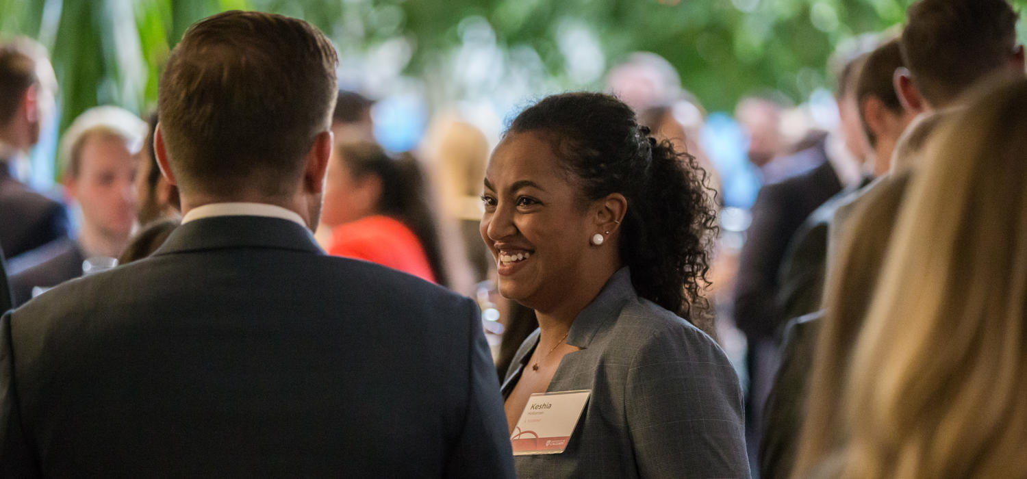 A Black female smiles in a crowd of people