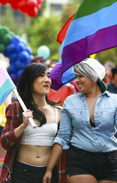 Students with trans flag and pride flag walking together at the 2017 Calgary Pride Parade withUOFCPRIDEPARADE