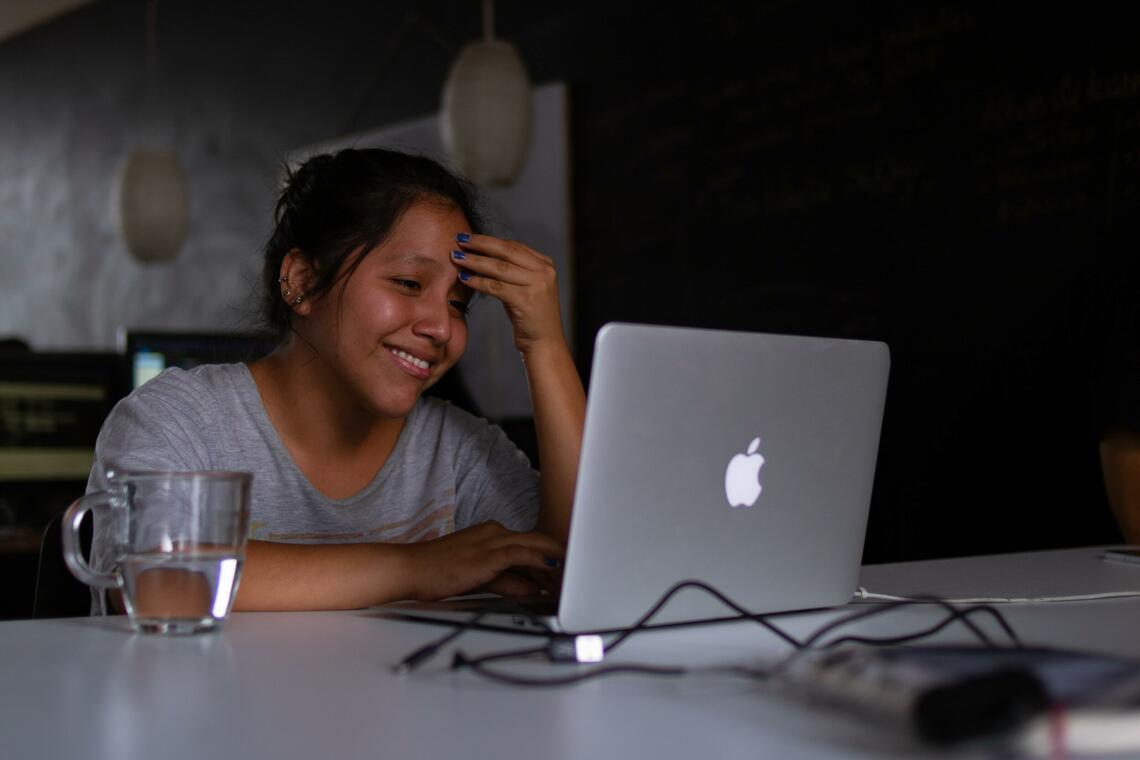 Smiling woman working on a lap top, University of Calgary Faculty of Social Work Field Education