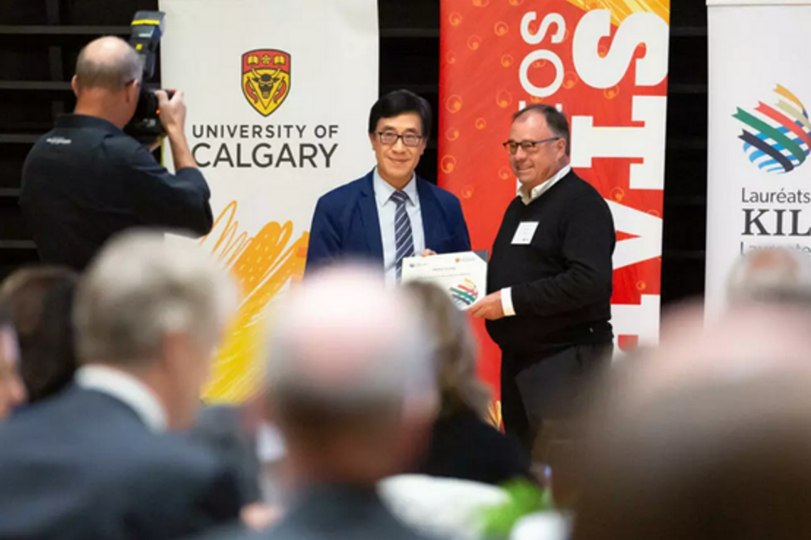 Dr. Henry Leung, left, receives the Killam Research Excellence Award from Killam managing trustee Bernard Miller.