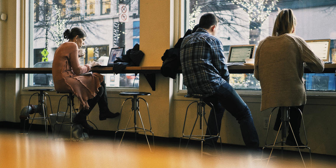 People working on laptops in a cafe