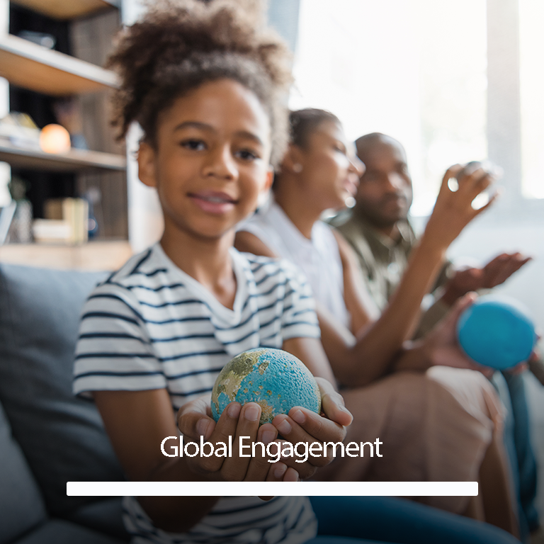 young girl holding up a small model of a globe