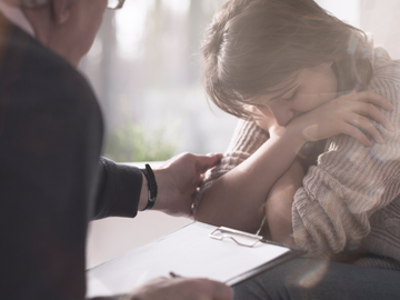 Psychologist comforting depressed and worried patient with phobia