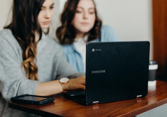 two people looking at a laptop