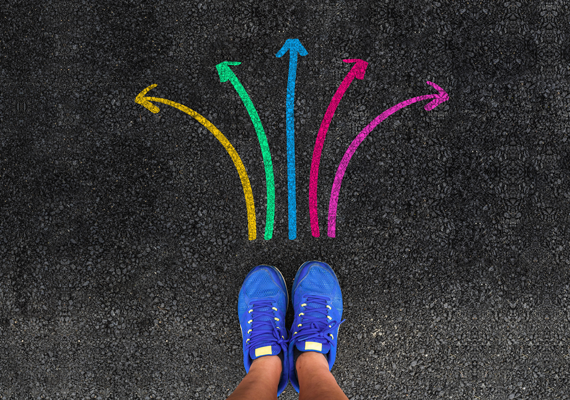 Person with a shoes are standing next to colorful direction arrow choices